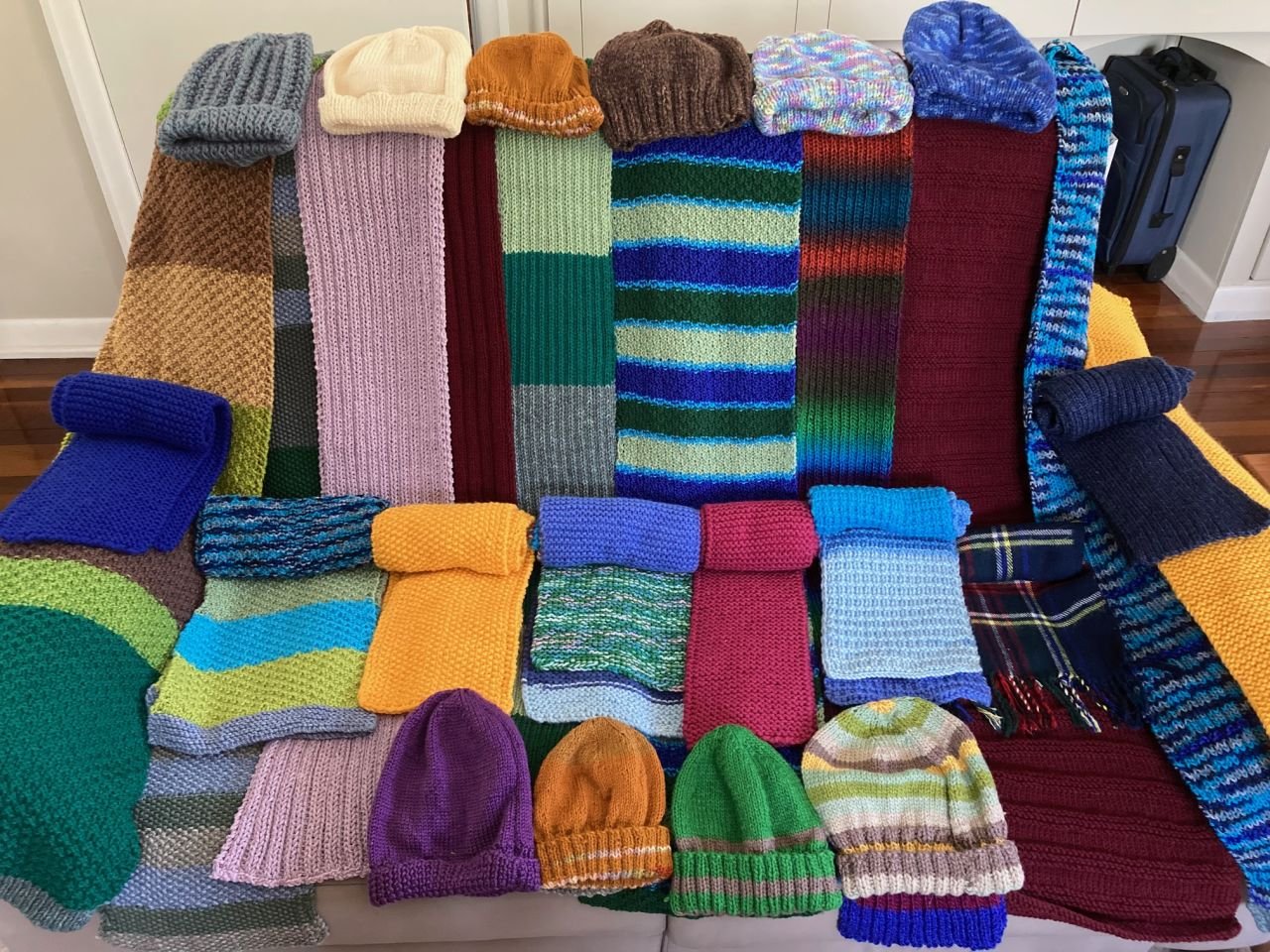 Beanies & Scarves knitted by members of Coorparoo Branch during 2021 for donation to the Brisbane Mission to Seafarers