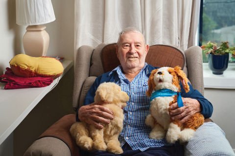 Carinity Brookfield Green aged care resident Stan Fryer with two robotic companion pets